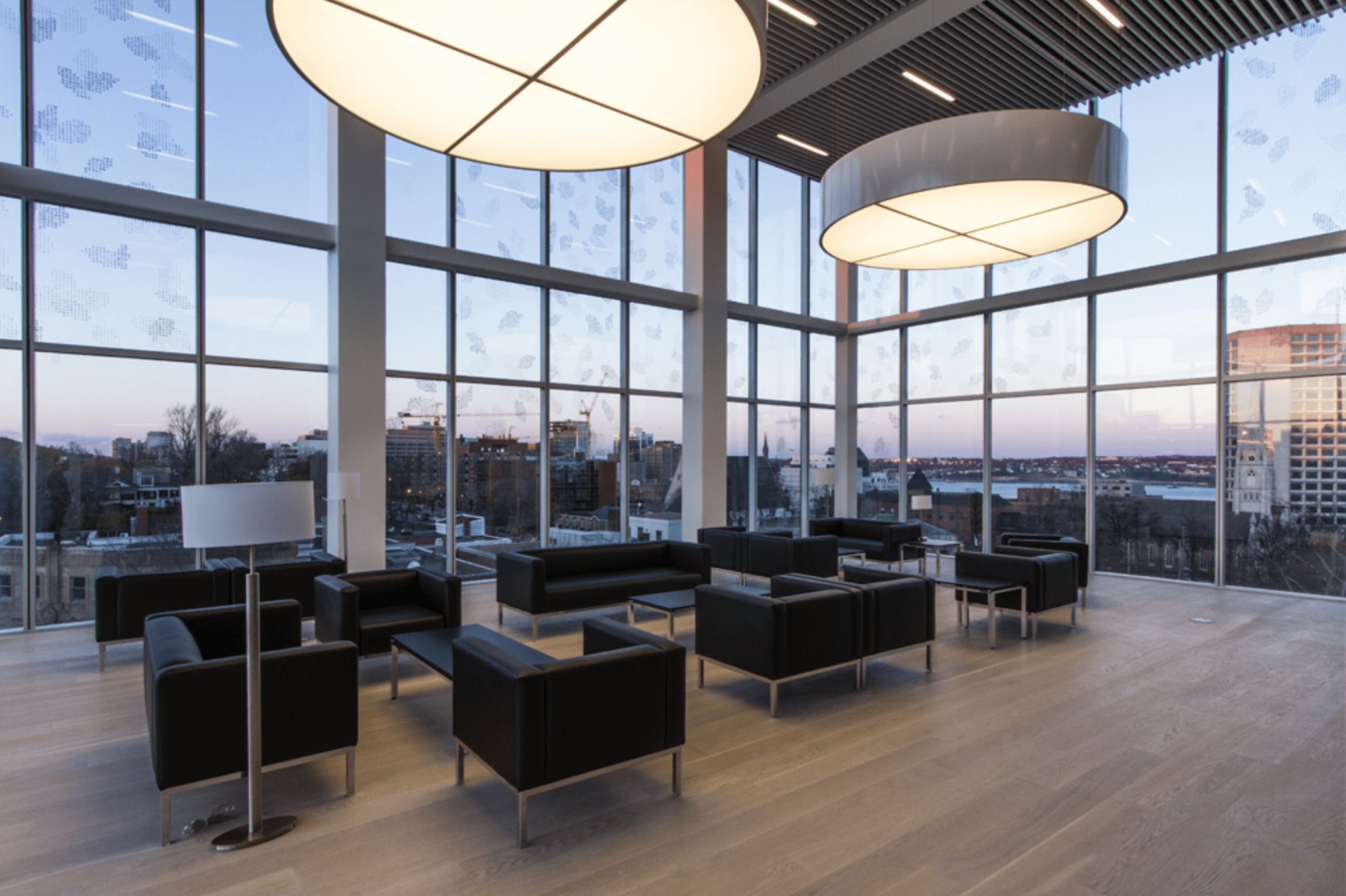The 5th floor of the Halifax Central Library at dusk, the skyline visible through floor-to-ceiling glass