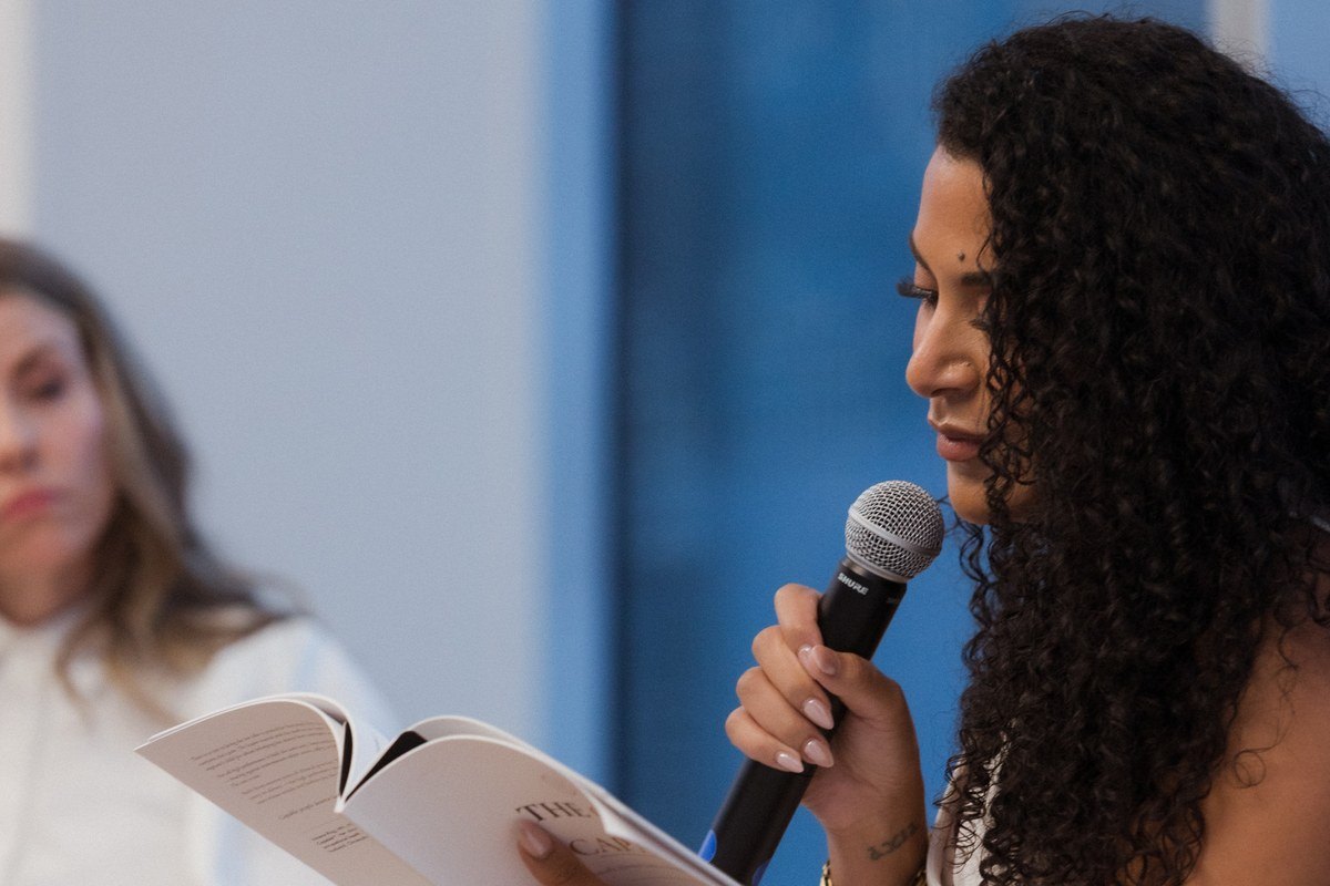 Verena Rizg reading from The Cost of Capable with host Rhiannon Rosalind at the Halifax book launch, Halifax Central Library, August 2026